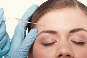 Woman receiving Botox injections in her forehead